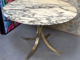 une table avec un plateau en marbre et un piètement en métal doré