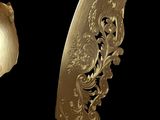 a gold spoon and a gold spoon with a flower design on it