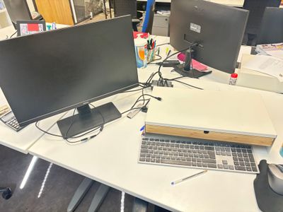 un bureau sur lequel sont posés deux ordinateurs et un ordinateur portable
