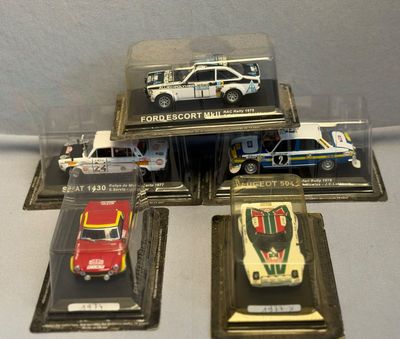 cinq modèles réduits de voitures exposés dans une vitrine