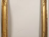 a gold picture frame with a white wall behind it