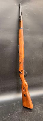 rifle on a metal surface with a gun in the foreground