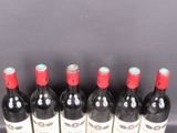 six bottles of red wine lined up in a row on a table
