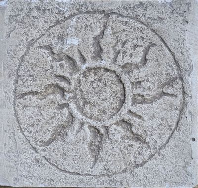 un bloc de pierre orné d'un motif représentant le soleil