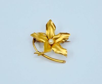 broche en forme de fleur jaune avec une perle au centre