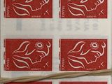 un gros plan sur une feuille de timbres rouges posée sur une table