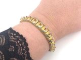 someone is wearing a gold bracelet with a crown on it