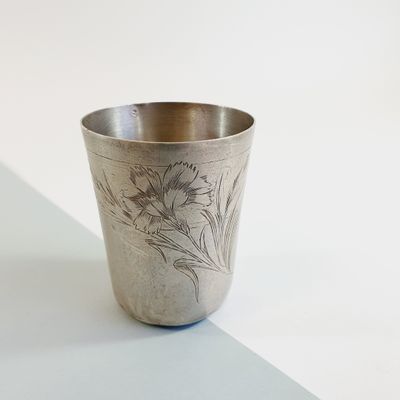 a silver cup with a design on it on a table