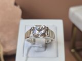 une bague en diamant posée dans une boîte blanche sur une table