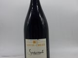 une bouteille de vin posée sur une table blanche