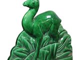 green ceramic deer figurine with leaves on a white background