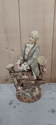 une figurine représentant une femme assise sur un banc