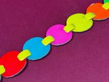 a close up of a colorful paper chain on a purple surface