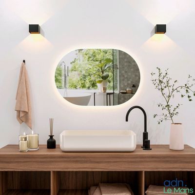 une salle de bains avec un lavabo et un miroir au mur
