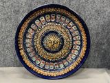 une image représentant une assiette bleue et dorée ornée d'une tête de lion