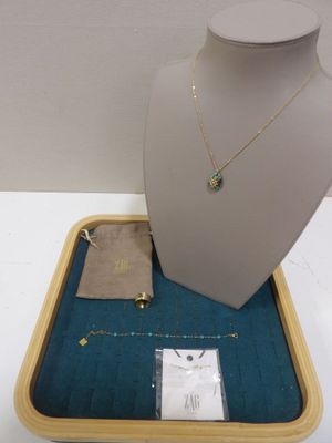 un collier, un bracelet et une pochette contenant des bijoux, exposés sur une table