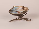 a small bowl on a stand with a bird on it