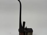 une pipe noire et deux briquets posés sur une surface blanche