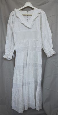 an image of a white dress on a hanger on a gray background