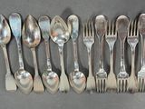 a lot of silver spoons and forks on the table
