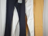 three men ' s pants hanging on a clothes rack in front of a white curtain