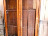 a large wooden cabinet with glass doors on the outside of it