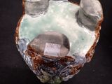 a small vase with a stone in it on a table