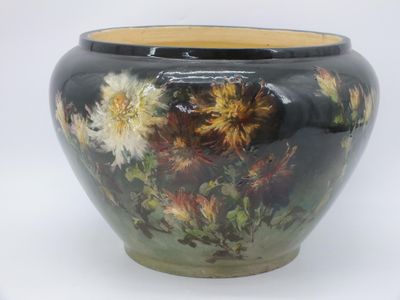 un vase noir orné de fleurs jaunes et blanches