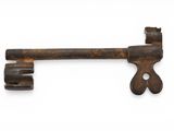 an old rusty key on a white surface with a white background