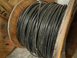 a spool of black wires on a reel in a garage