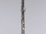 a black and silver clarinet on a clear stand