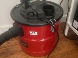 un aspirateur rouge posé par terre à côté d'une télévision