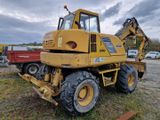 une photo d'un engin de chantier jaune garé sur un parking
