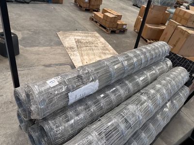 de nombreux rouleaux de fil métallique sur une palette dans un entrepôt