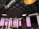une grande salle avec de nombreuses chaises et un écran de projection