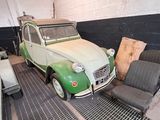 a green and white car sitting in a garage