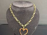 un collier en or avec un pendentif en forme de cœur sur un mannequin