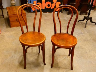 deux chaises en bois assises l'une à côté de l'autre dans une pièce