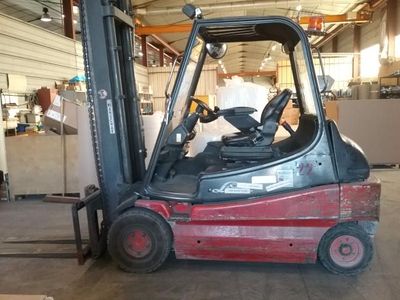 a red fork lift truck parked in a warehouse