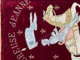 a red velvet banner with a picture of a man holding a sword