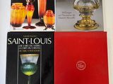 three books on a table with a lamp, vase, and other items