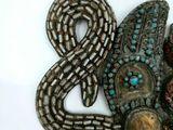 a metal sculpture of a snake and a snake head on a white surface
