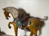 a statue of a horse on a shelf next to a mirror