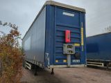 a blue container truck that is parked on the side of the road