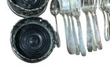a lot of silverware sitting on a white surface