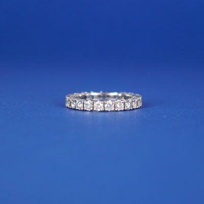 un gros plan d'une bague en diamant posée sur une surface bleue