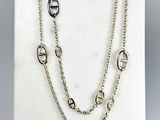 a close up of a necklace on a display on a white surface