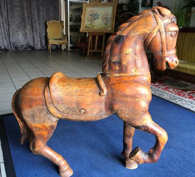 un cheval de bois posé sur un tapis bleu
