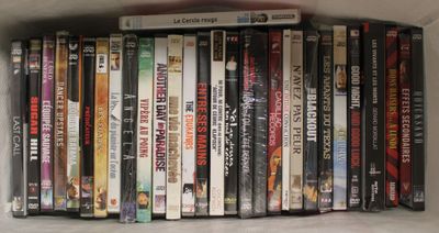de nombreux DVD empilés sur une étagère, dans une boîte blanche