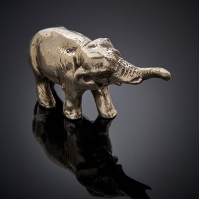 statue d'un éléphant sur une surface réfléchissante, avec un fond noir